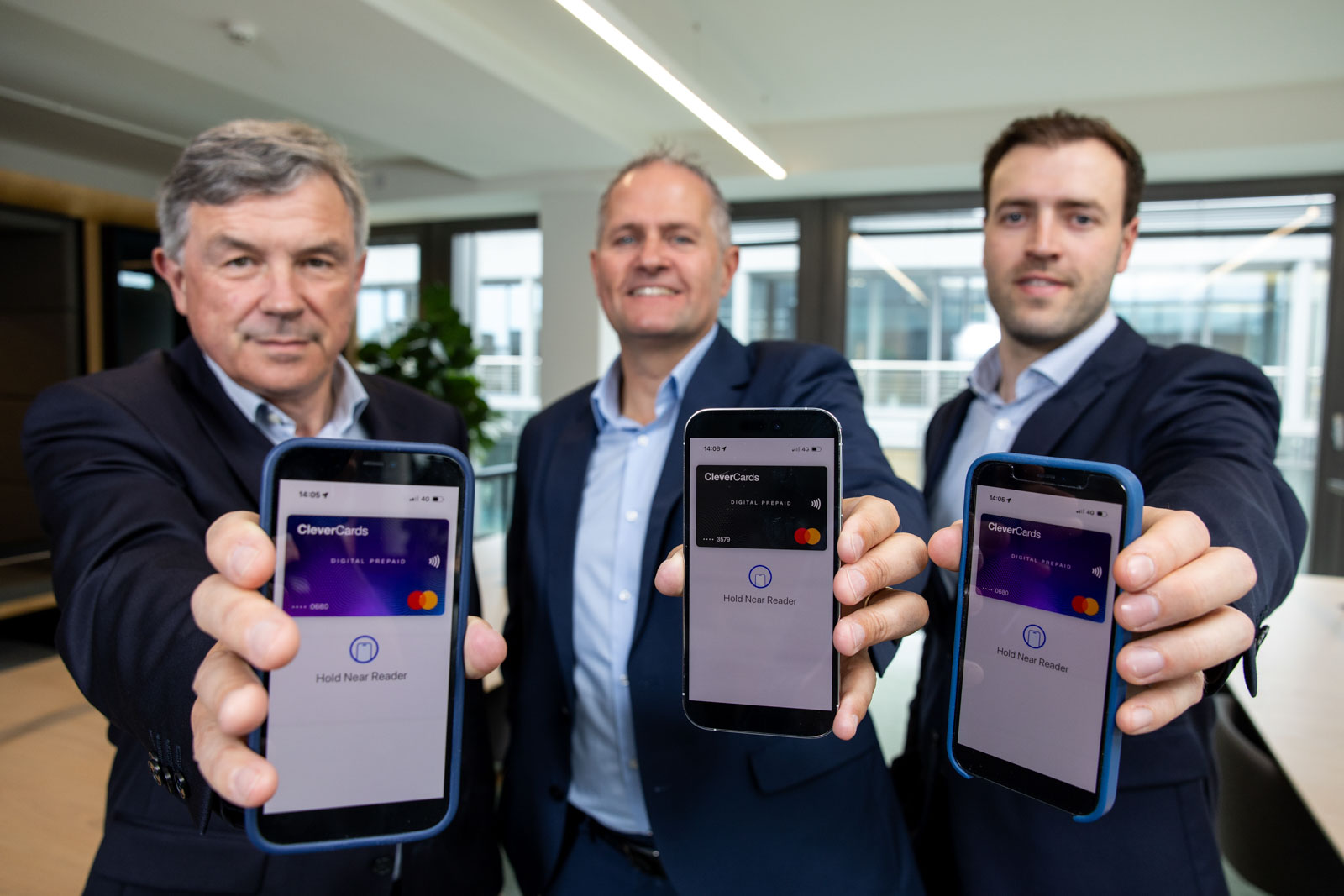 Launch of new app, 3 men in suits, holding phones